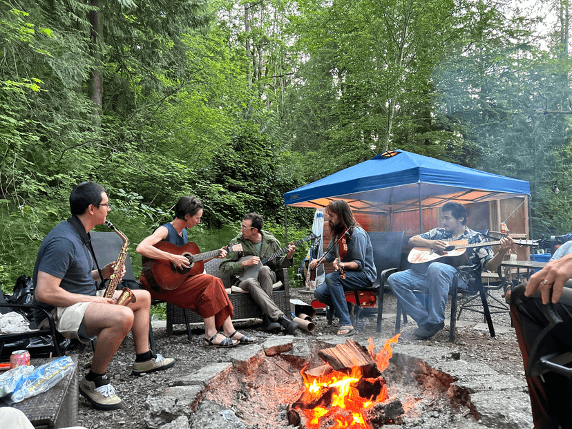 Community gathering around fire at Pickin' Round the Fire bluegrass jam